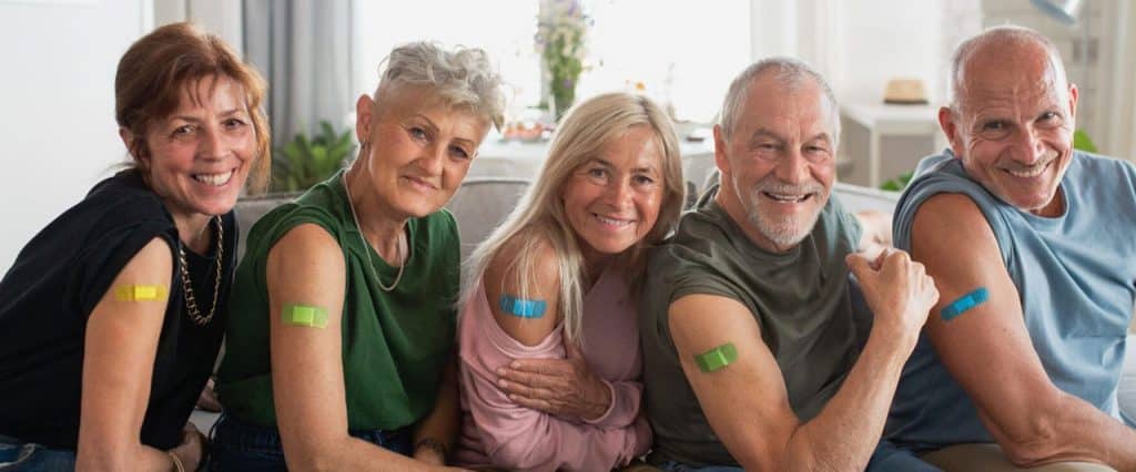 Group of five adults with plasters after their vaccination
